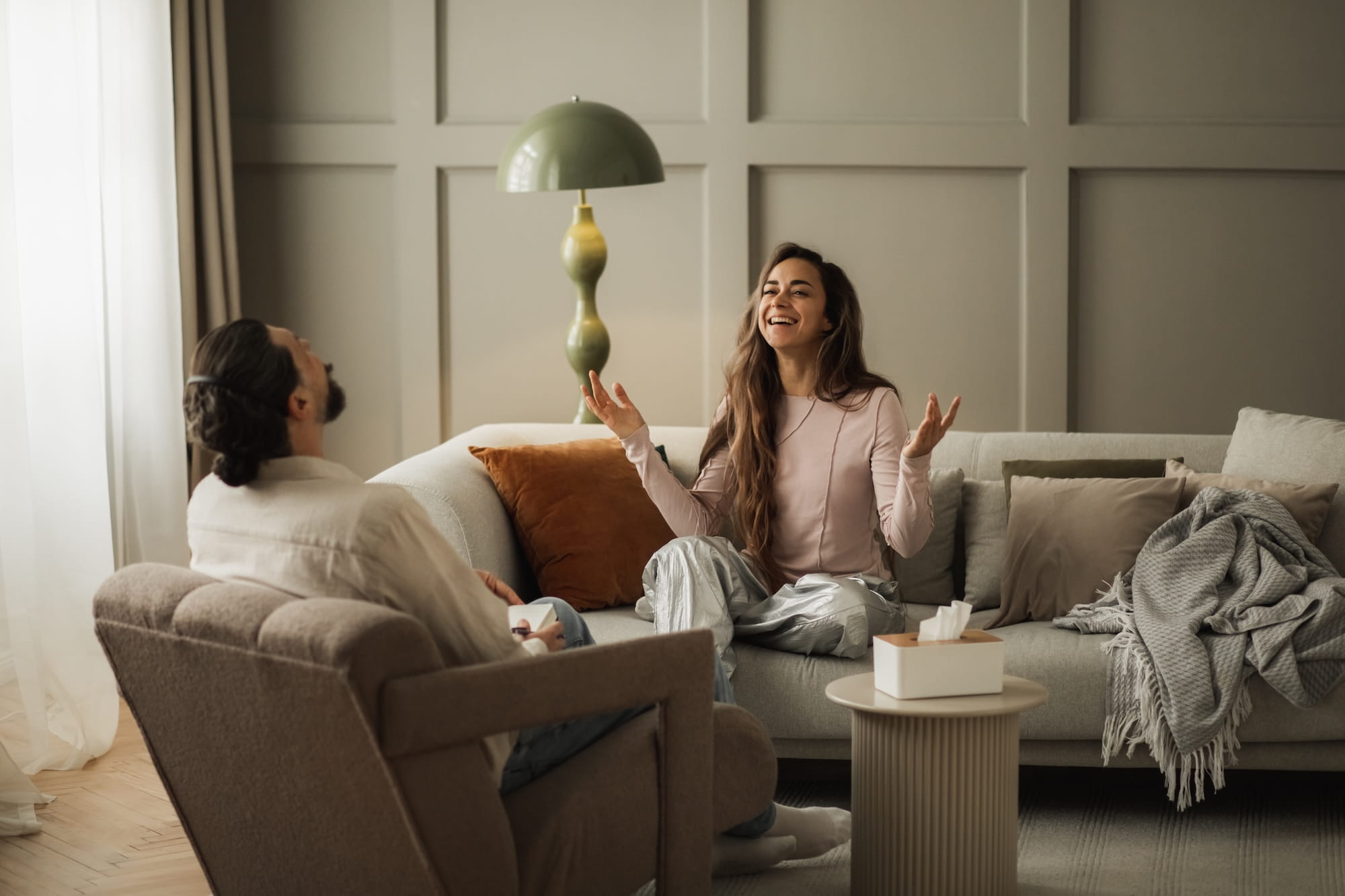 Woman and man sitting on couches, having good conversation